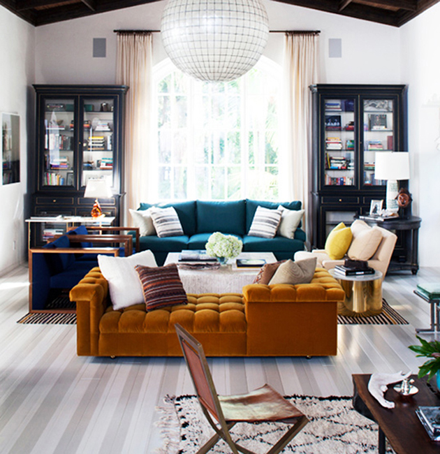 living room: painted wood floors, bold couches, double bookshelves